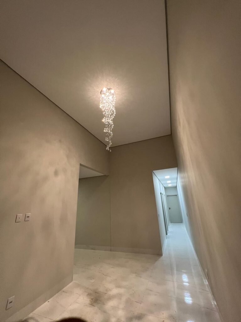Casa Villa Segura Provençal — Ambiente interno com pé-direito alto, pendente e piso de aspecto marmorizado