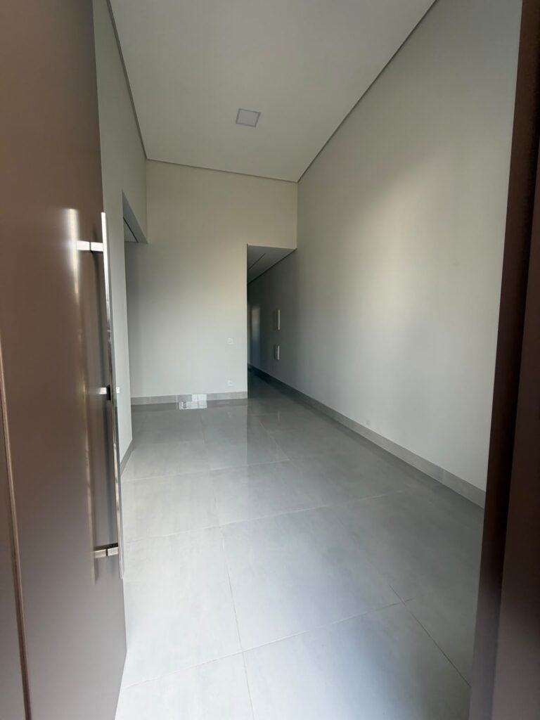 Villa Segura · Rua 02 — Sala com pé-direito alto e acabamentos em tons claros