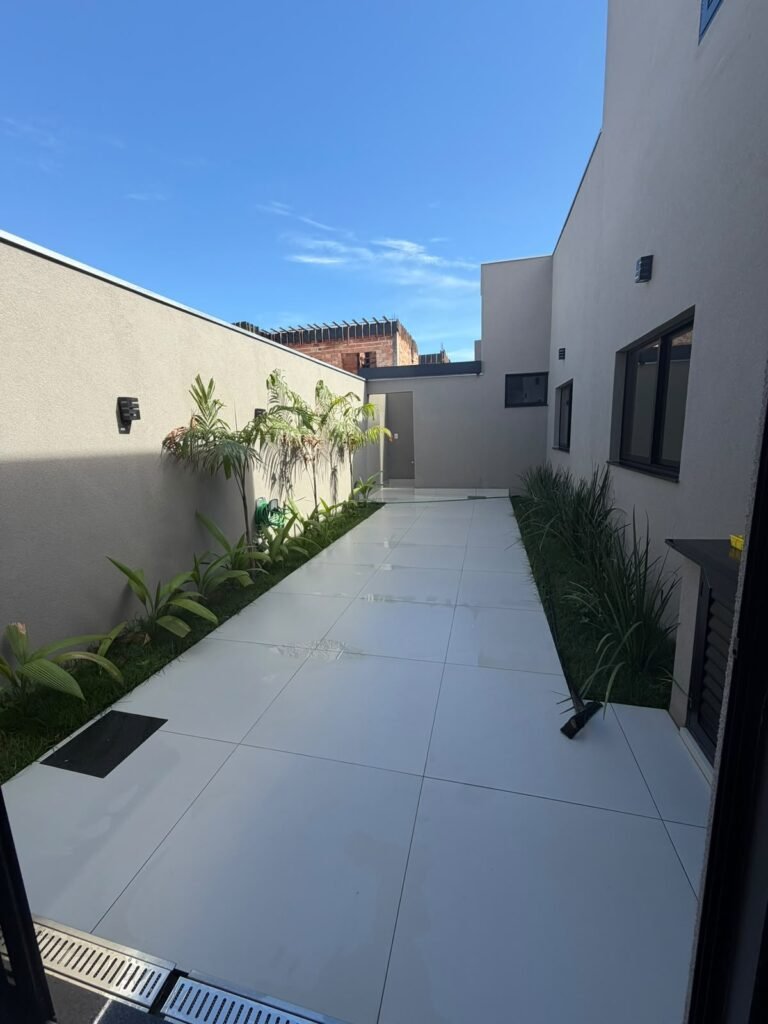 Villa Segura · Rua 02 — Quintal pavimentado com jardins nas laterais